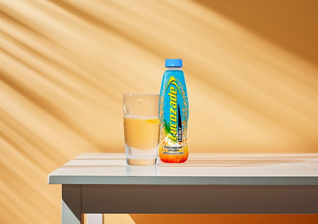 A bottle of Lucozade sitting on a table in the sunshine