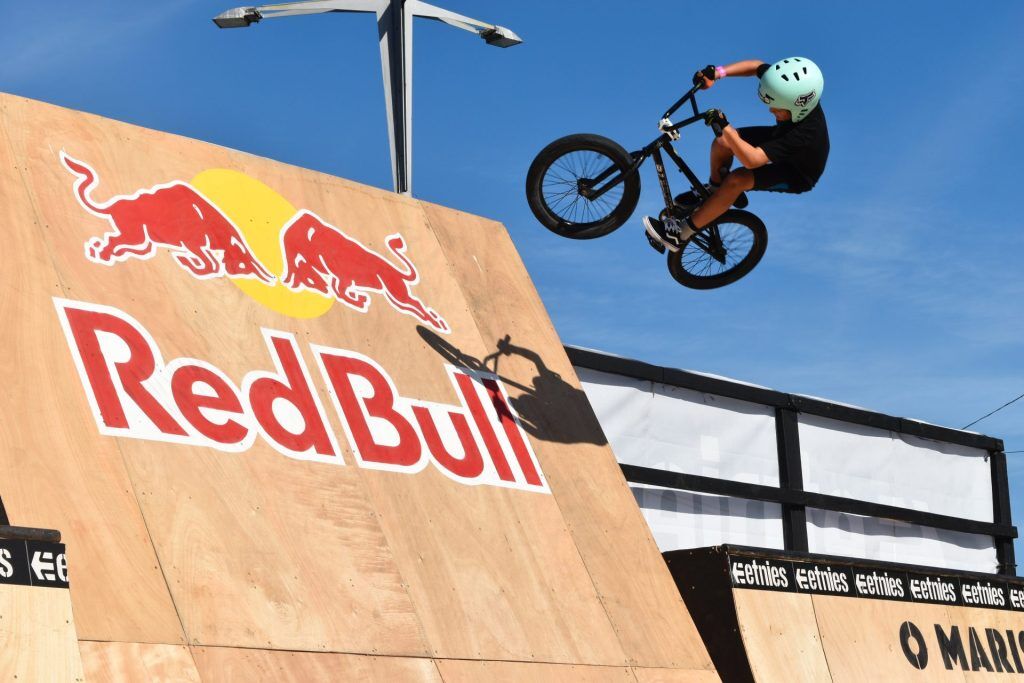 Bicycle rider flying in the air off of a Red Bull Logo ramp